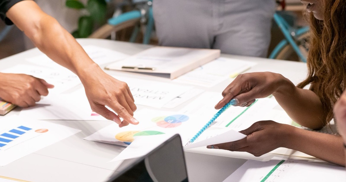 A marketing team reviewing charts and reports together at a desk